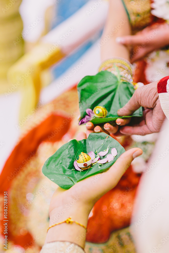 Fototapeta premium Close-up photos of the beetle leaves and religious accessories used for the Hasta Melap ceremony of traditional Hindu weddings