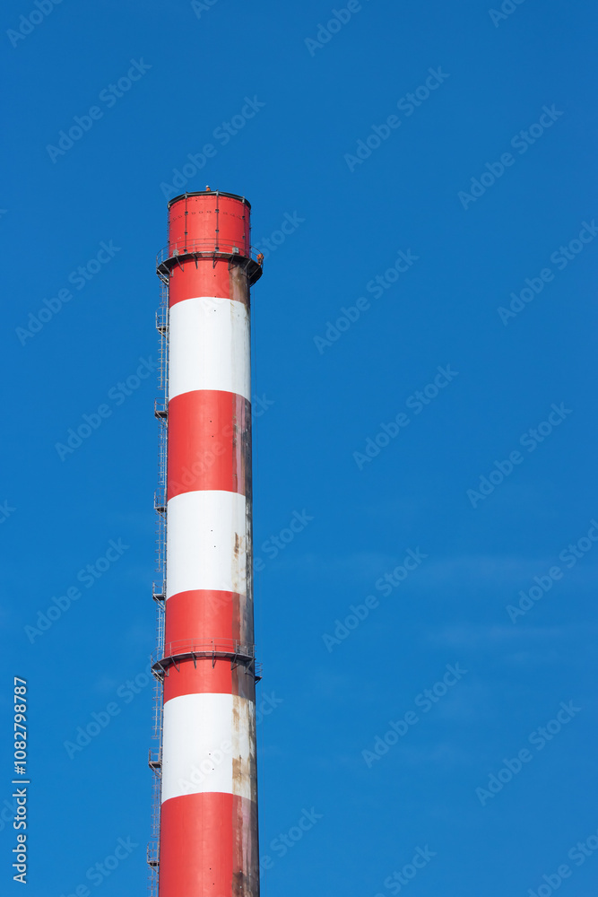 red and white industrial chimney stack against a blue sky red and white industrial chimney stack against a blue sky