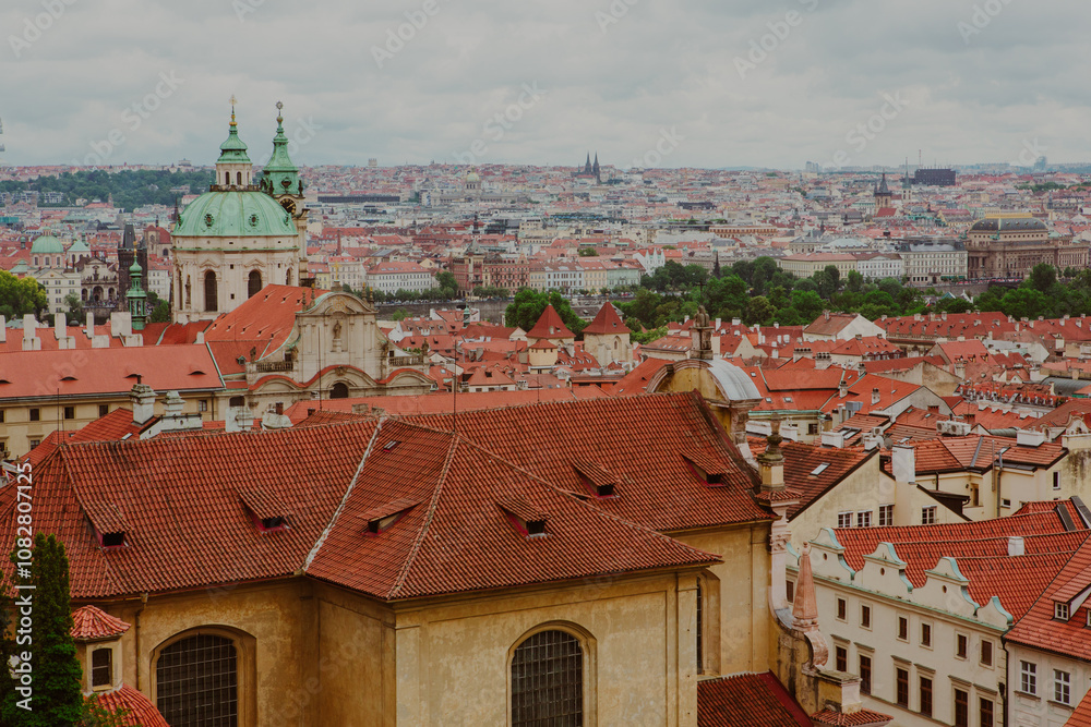 Obraz premium The skyline of Prague overlooks red rooftops of historic buildings. Discover the charm of Prague in Czech Republic - iconic landmarks, historic architecture, medieval styles and scenic views.