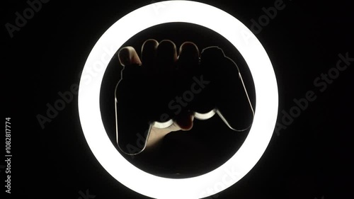 female hands hold a gamepad on a black background. joystick controller for gaming platform close-up. Esports and cybersports concept