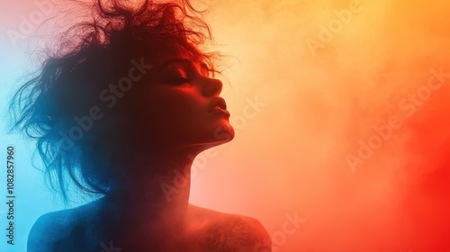 A dramatic silhouette of a woman surrounded by vibrant, colorful lighting, blending hues of red, orange, and blue, manifesting creativity and emotional expression.