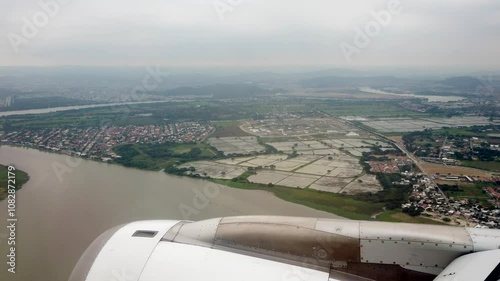 Airplane approaches guayaquil, ecuador, showcasing a river and the urban landscape below in a scenic aerial view