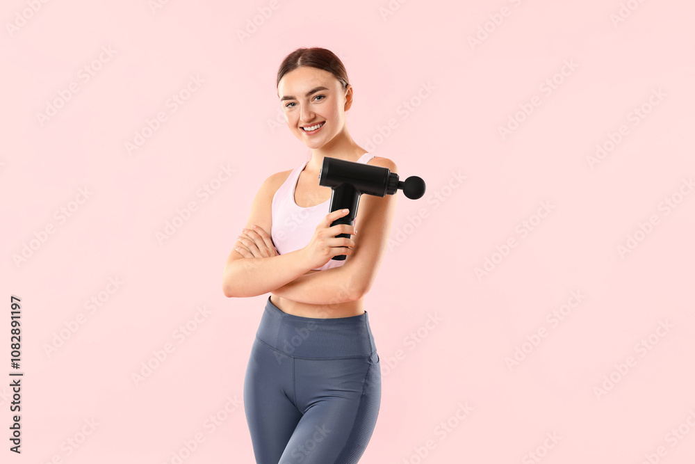 Young woman with percussive massager on pink background Young woman with percussive massager on pink background