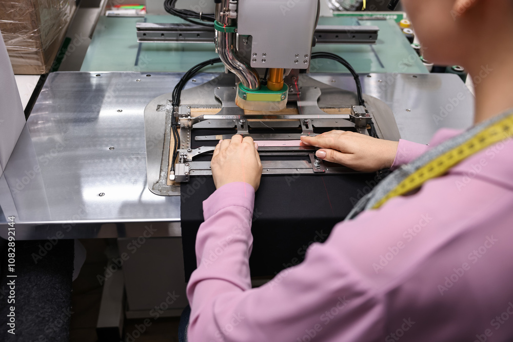 Young woman working with machine in professional workshop, closeup Young woman working with machine in professional workshop, closeup