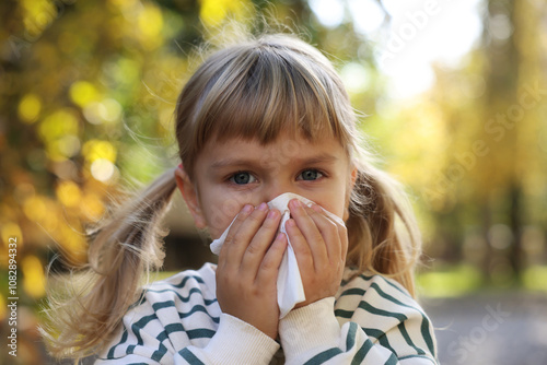 Little girl with runny nose in park