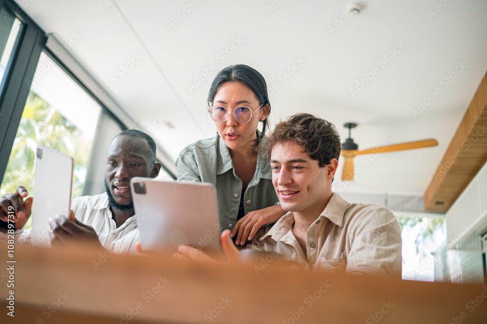 A group of young adults of varying ethnicities collaborate on tablets in a well-lit, modern office space, their professional attire suggesting a business environment. A group of young adults of varying ethnicities collaborate on tablets in a well-lit, modern office space, their professional attire suggesting a business environment.