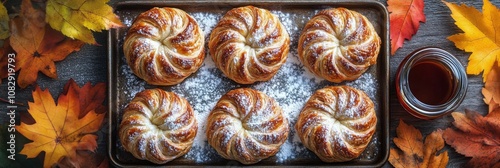 Freshly baked pastries arranged on a rustic wooden table surrounded by autumn...