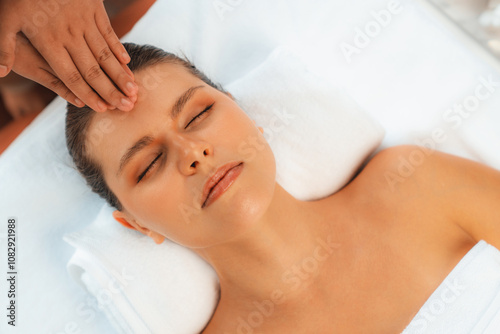 Panorama top view of woman enjoying relaxing anti-stress head massage and pampering facial beauty skin recreation leisure in dayspa modern light ambient at luxury resort or hotel spa salon. Quiescent