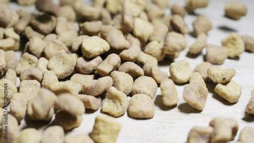 Pouring dry pet food onto a wooden table, creating a delightful pile of crunchy kibble