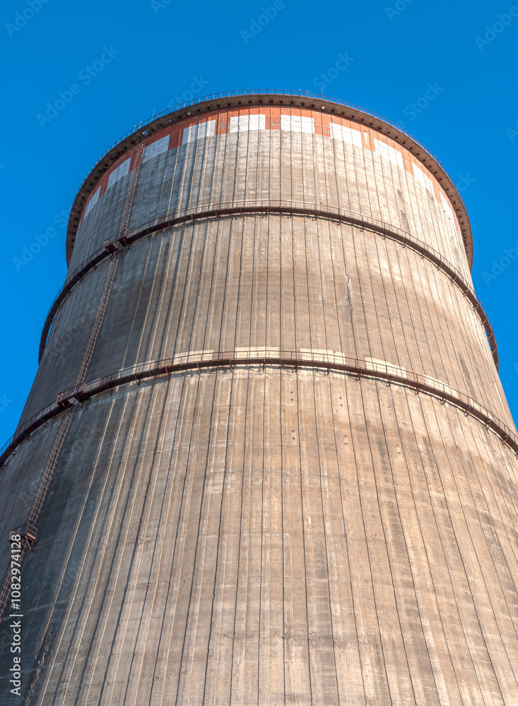 Tall cooling tower against a bright blue sky Tall cooling tower against a bright blue sky