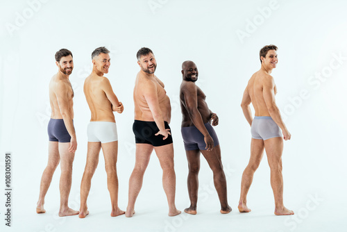 Group of multiethnic men posing for a male edition body positive beauty set. Shirtless guys with different age, and body wearing boxers underwear photo