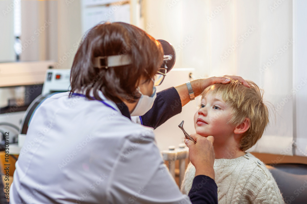 Fototapeta premium Boy 4-5 years old being examined by otolaryngologist