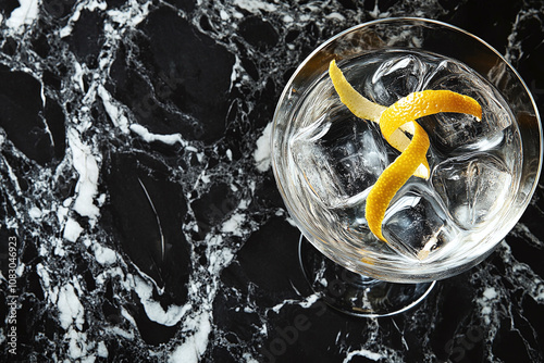 A classic martini with twisted lemon peel on black marble. photo