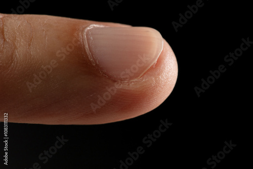 Clean normal long fingernail without color or coating on nail. Long clean fingernail to show texture detail of uneven nail and scratch skin, black background isolated