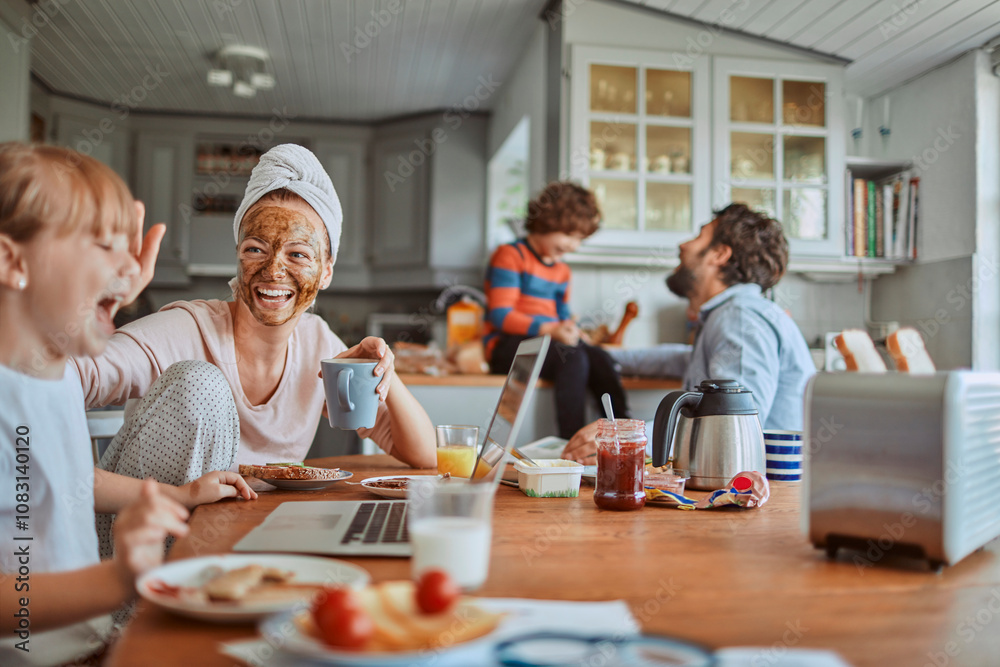 Obraz premium Happy family enjoying breakfast together in kitchen