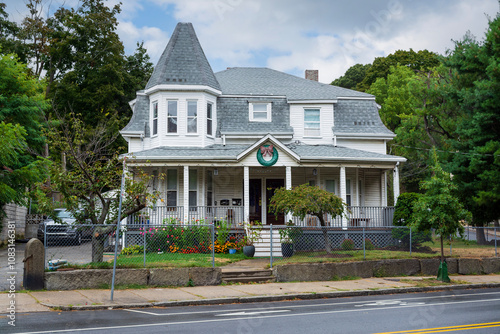 Historical-style beautiful family home with turret and mansard roof surrounded by greenery in Brighton, Massachusetts, USA
 photo