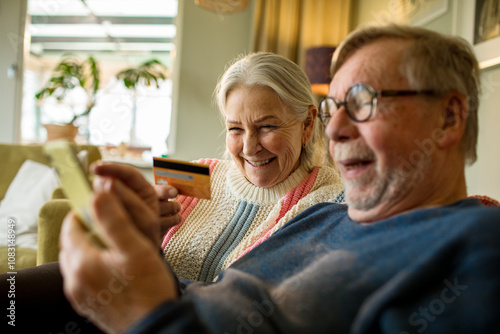 Wallpaper Mural Senior couple online shopping on laptop on the couch at home Torontodigital.ca