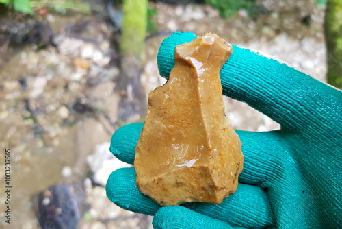 Flint scraper found in river, tool of Stone Age man, field photo, Russia photo