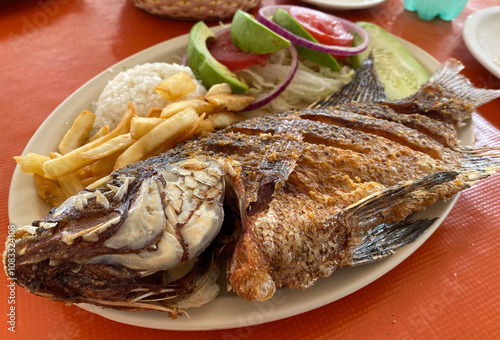 Mojarra frita con arroz, ensalada y papas fritas photo