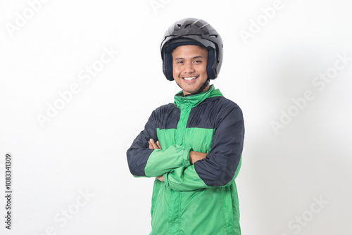 Portrait of Asian online taxi driver wearing green jacket and helmet, standing with crossed arms. Isolated image on white background photo