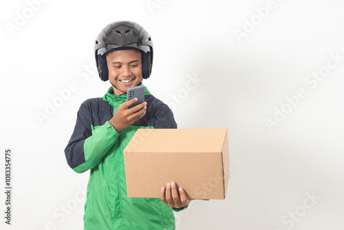 Portrait of Asian online taxi driver wearing green jacket and helmet holding a box and scanning or capturing the package. Isolated image on white background photo