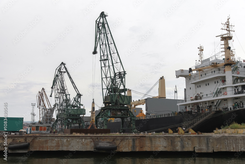 Fototapeta Portal cranes standing on quay in Varna port