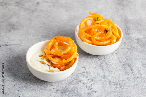 Tableau sur toile Jalebi, crispy and syrup-soaked, served warm with creamy, chilled rabdi for a deliciously sweet and rich combination