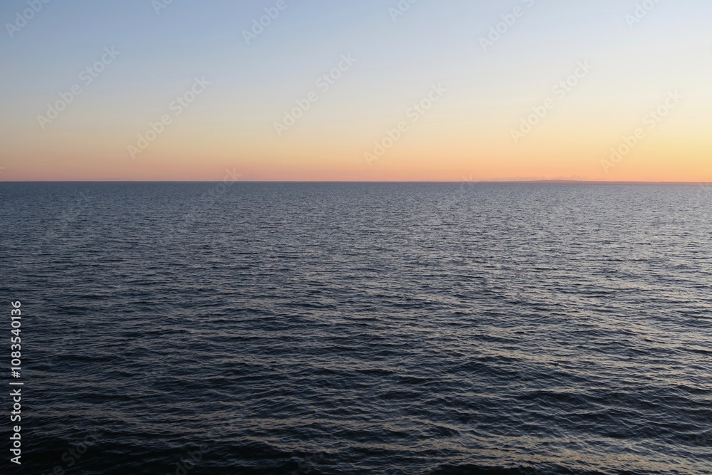 Obraz premium Von Bord einer Fähre von Kopenhagen über Frederikshavn nach Oslo ist der Sonnenuntergang über dem Kattegat zu sehen. Die See ist ruhig an diesem Sommerabend.