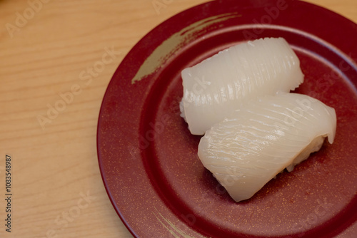 Ika Sushi or fresh squid, Japanese Restaurant that specializes in Japanese cuisine. serving on red plate.