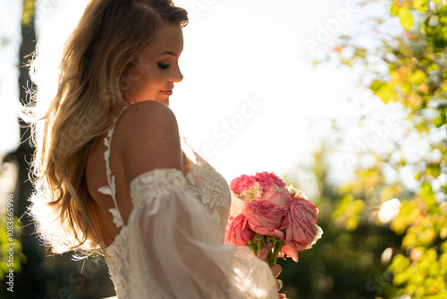 Beautiful bride on white wedding dress with bridal bouquet photo