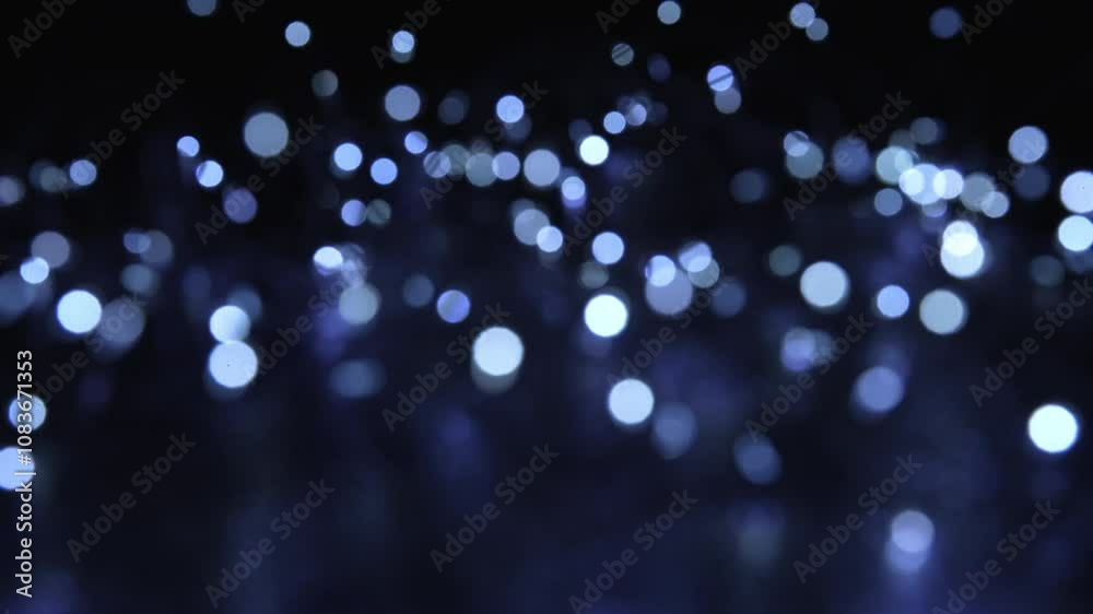 A soothing video of soft blue bokeh lights gently shimmering and fading against a black background, perfect as a tranquil backdrop or overlay.