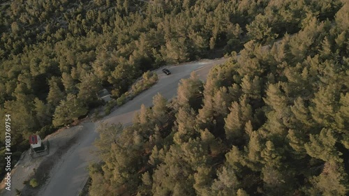 Motorbike in the pine forest on the mountain, aerial footage on sunset  photo