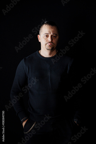Portrait of a Thoughtful Man in Dark Clothing Against a Black Background