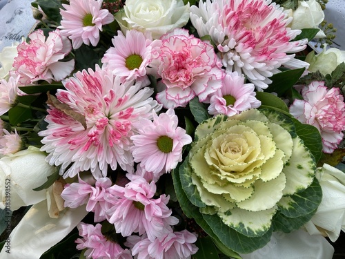 Helle Blumen in Rosa im Trauerkranz nach Beerdigung auf dem Friedhof photo