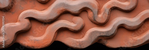 A close up of a red and brown surface with a wave pattern. The surface is made of sand and he is a part of a larger structure. Concept of movement and fluidity