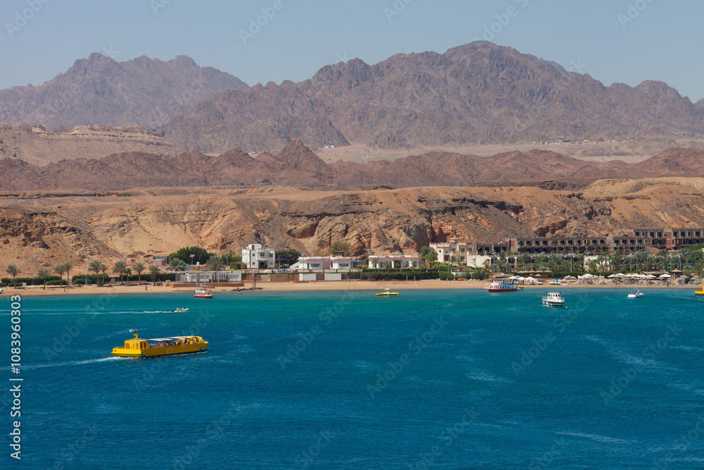 Fototapeta premium Panorama of Sharm el-Sheikh, Sharm El Maya bay. Excursion submarines, Red sea and Sinai mountains on a background. Boat trips and sightseeing in Egypt, Sharm el-Sheikh.
