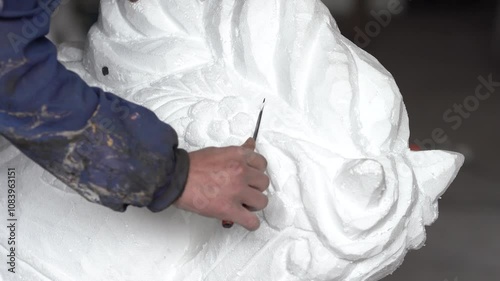 Sculptor's hands straightening and shaving a styrofoam statue. (Taken with 4k custom settings and light)