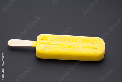 White with ice cream and yellow frosting. dessert sweet food concept. banana on stick lies on a . a banana on a stick lies on a white with yellow ice cream lifestyle.