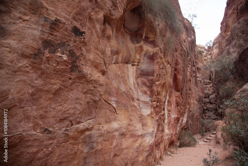 A narrow passage between steep rock formations in the siq at Petra the ancient City Al Khazneh in Jordan photo