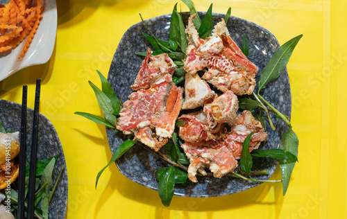 vietnamese street food. Cang cum num. Vietnamese salt and pepper crab. Cum Num crab claw salted accompanied by fresh herbs and red chilies. photo