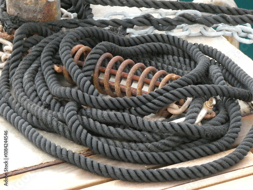 mooring rope coiled in the harbor, captured in a dramatic contrast. The texture of the ropes and the shadow details create a sense of depth, while the lack of color highlights the strength 