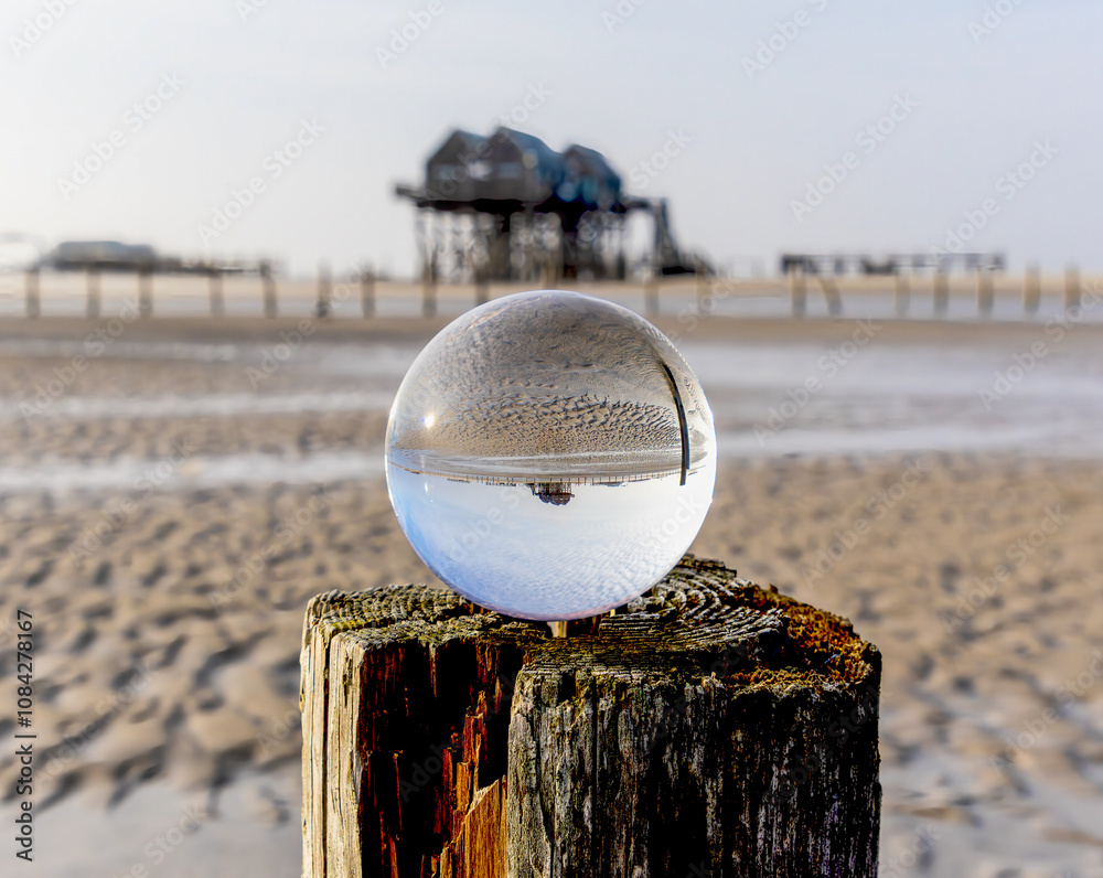 the pile dwellings at low tide in Sankt Peter Ording through a glass ball