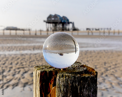 Obraz na płótnie
the pile dwellings at low tide in Sankt Peter Ording through a glass ball w salonie