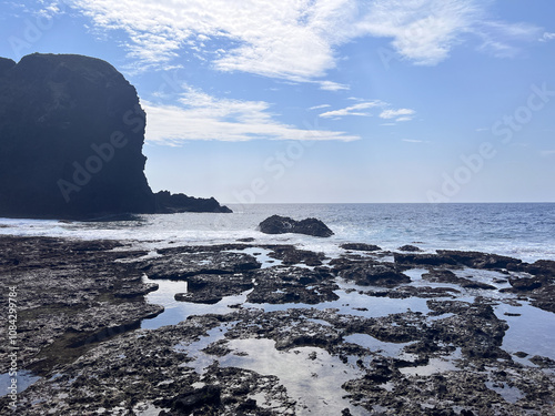 Serene Coastal Rock Formation Under a Clear Blue Sky