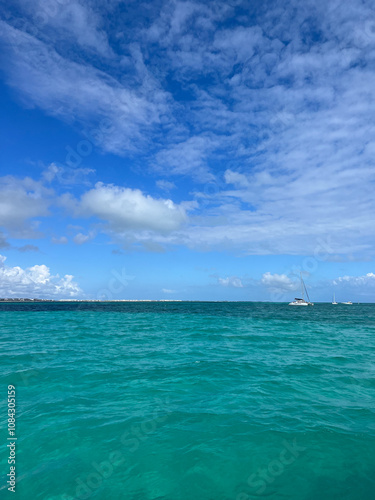 Serene Ocean View Under Clear Blue Sky with Sailboats