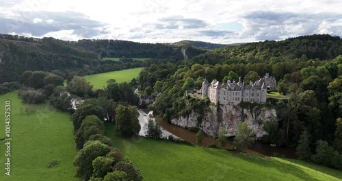 Ascending aerial footage of Walzin Castle over the river Lesse in the city of Dinant, Belgium photo