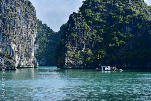 Ha Long Bay, Vietnam: Towering limestone cliffs, a traditional fishing village, and mountains rising above turquoise waters. 