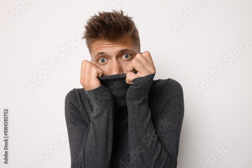 Portrait of scared young man on light background