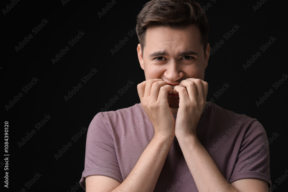 Portrait of scared young man on black background, space for text Portrait of scared young man on black background, space for text
