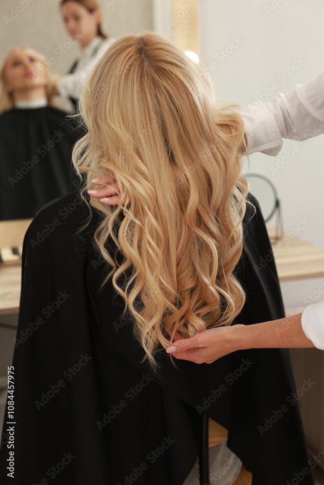 Fototapeta premium Hair cutting. Professional hairdresser working with client in salon, closeup
